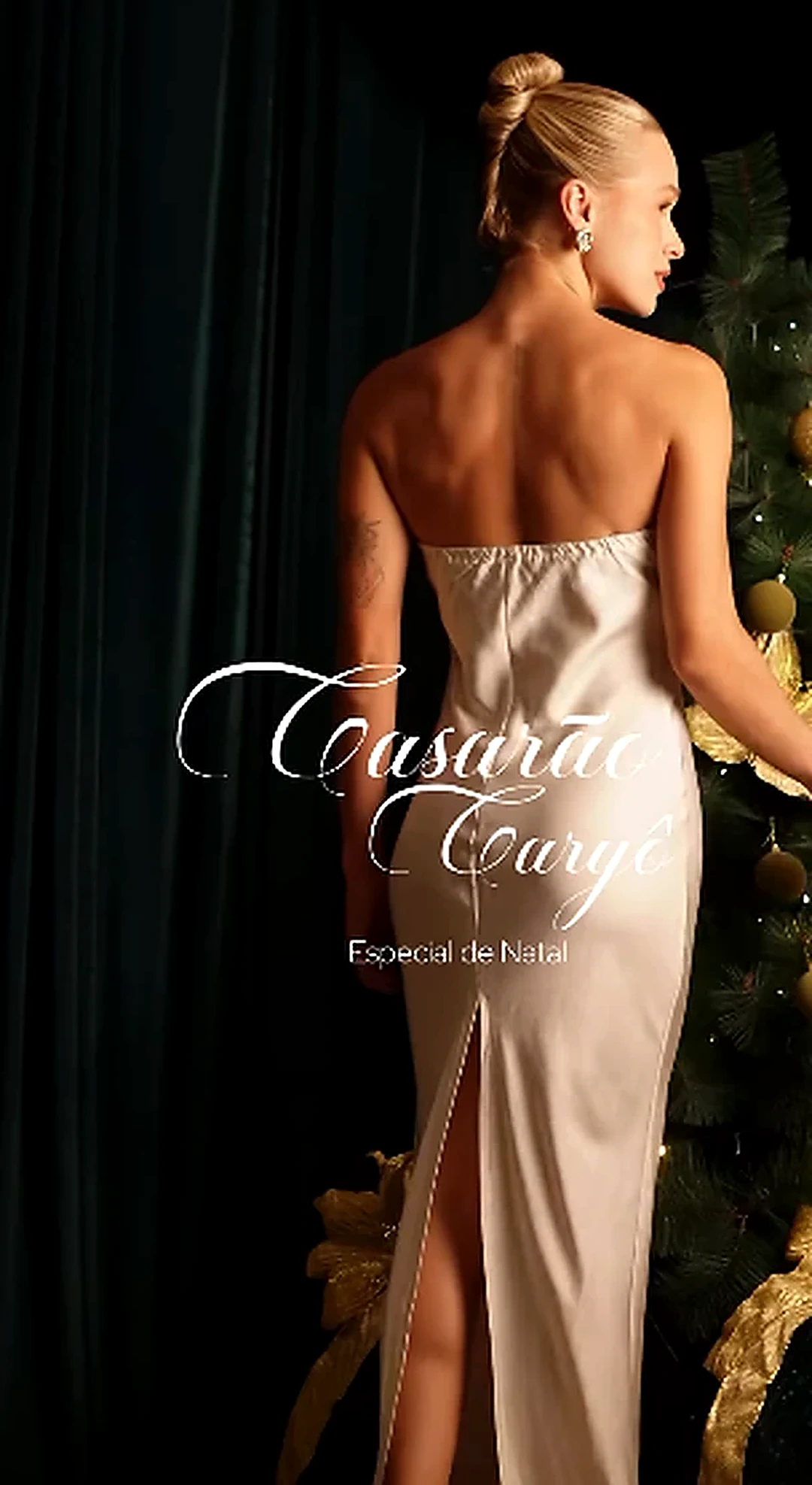 Editorial de Natal do Casarão: modelo de vestido acetinado claro junto ao cenário verde e dourado